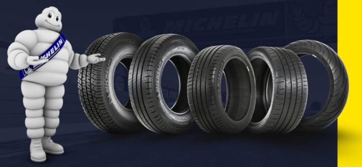 Propaganda da marca Michelin com pneus, fundo azul e o mascote ao lado.