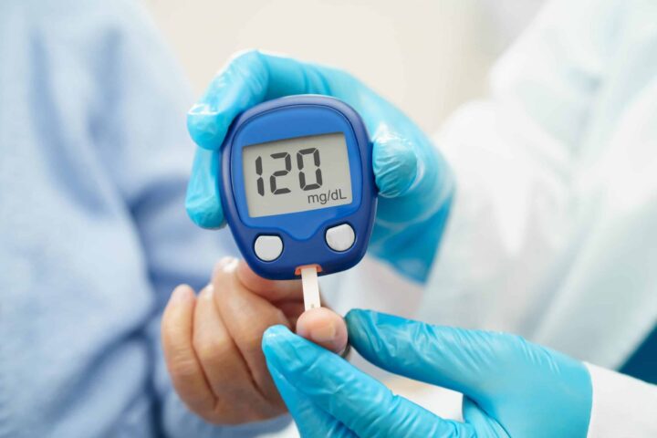 Médico usando medidor digital de glicose para verificar o nível de açúcar no sangue da amostra para tratar diabetes.