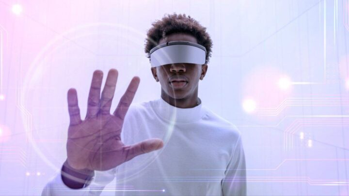 Rapaz negro com óculos vitual simula toque em tela à sua frente