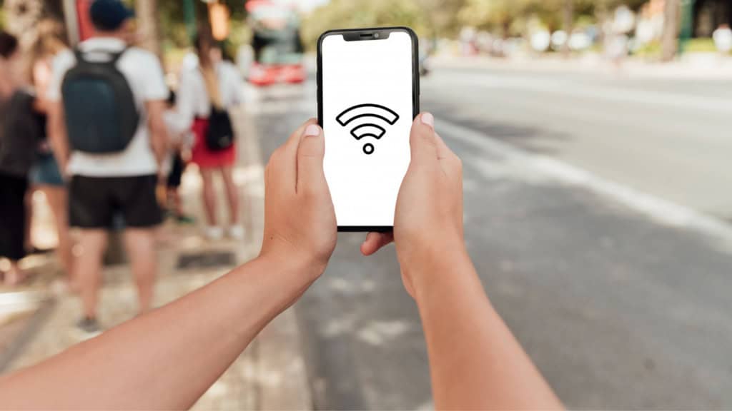 Visão em primeira pessoa de alguem que segura celular com sinal de wifi grande na tela